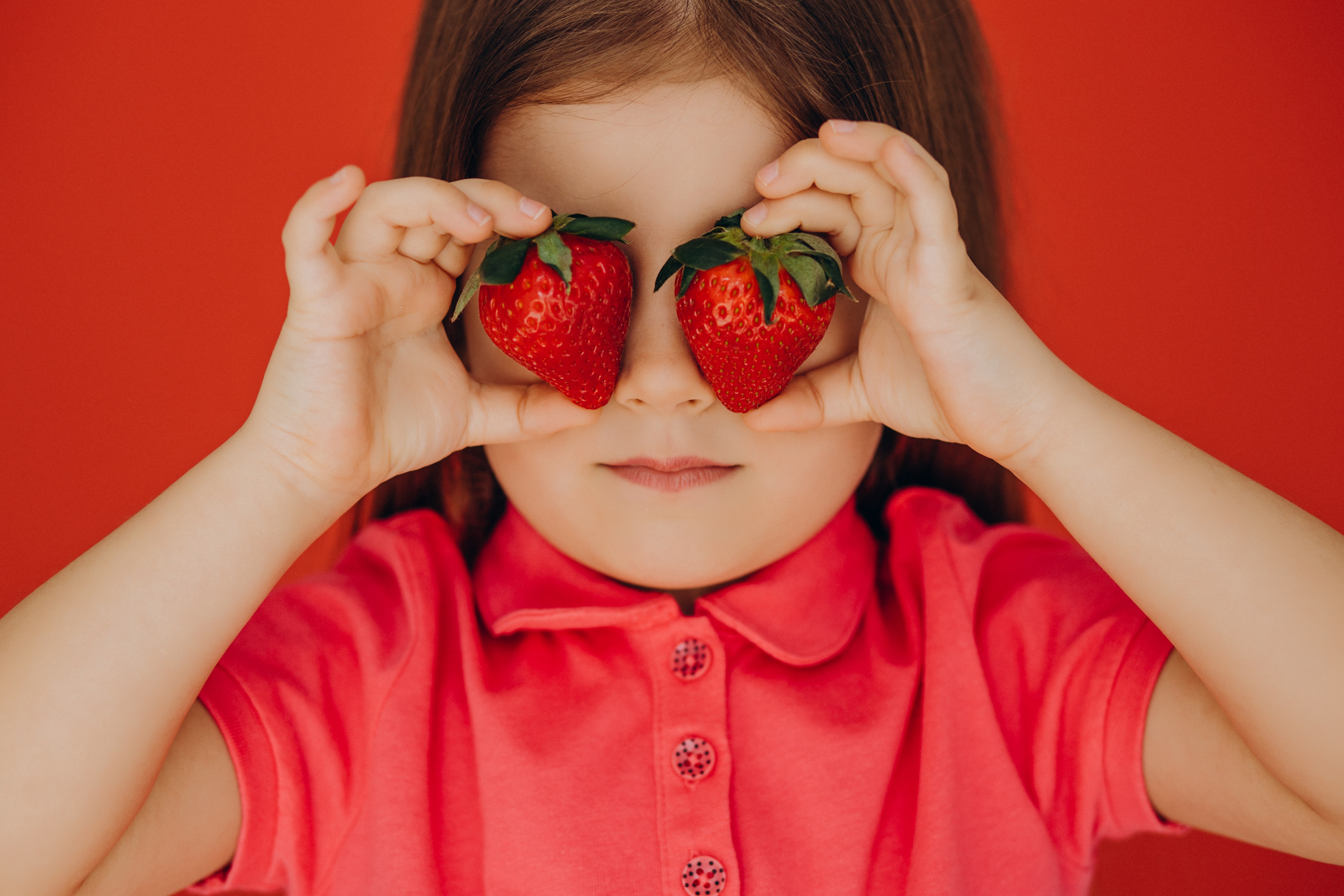Little girl holding two delicious stawberries